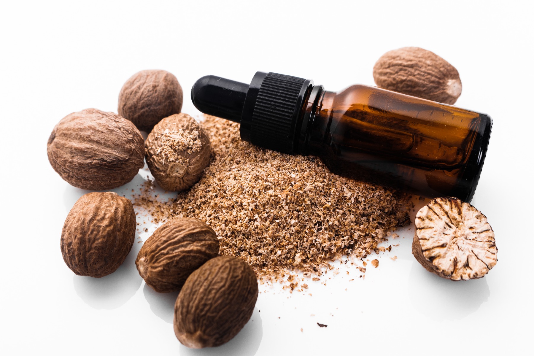 Nutmeg oil in bottle with nutmegs 