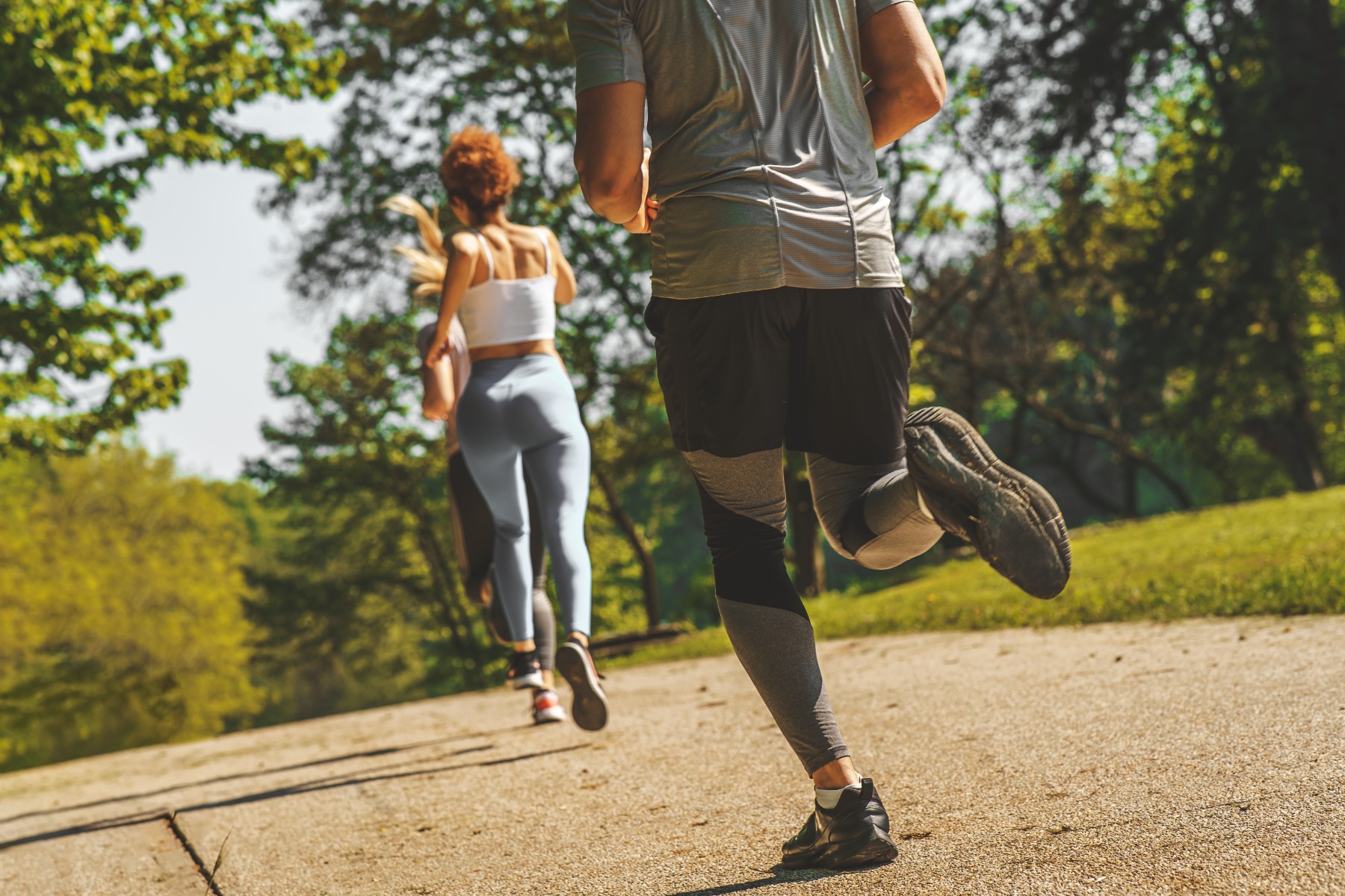 A group of people exercise and run at the park