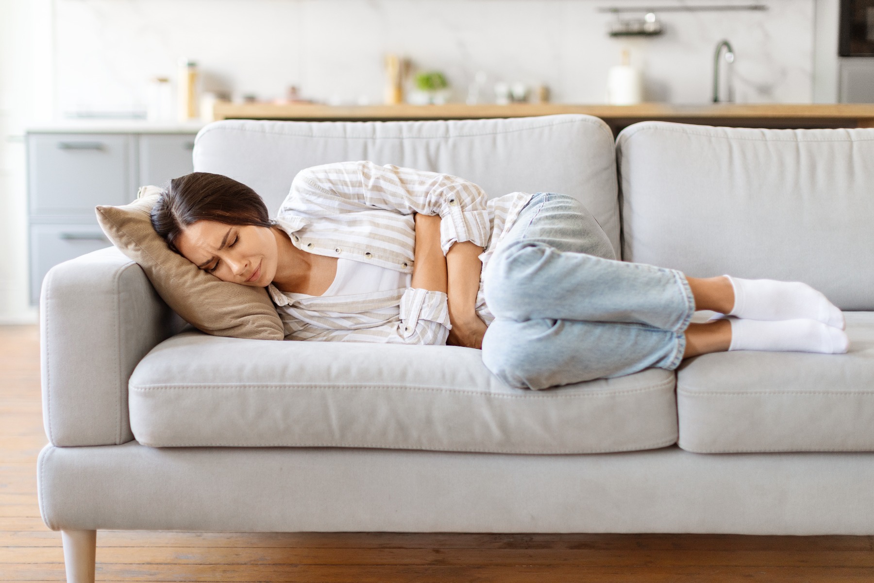 Lady on sofa with cramps 